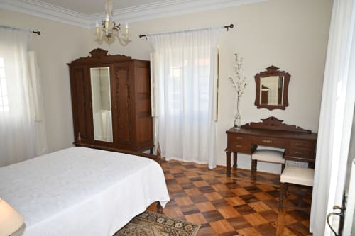 Chambre élégante à Villa Sor à Ponte de Sor avec armoire ancienne en bois, coiffeuse, parquet et literie blanche