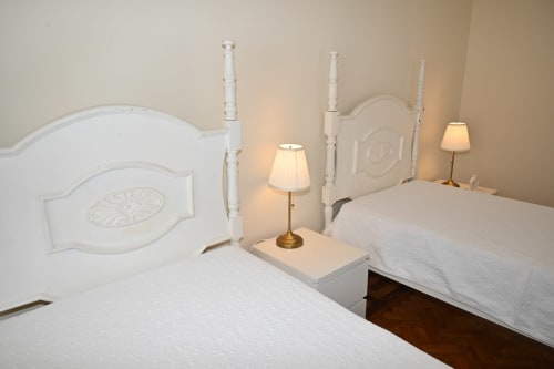 Chambre double à la Villa Sor à Ponte de Sor avec lits en bois blanc et lampes de table en laiton