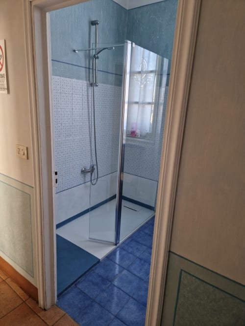 Moderna cabina doccia in vetro con piastrelle blu presso B&B La Corte Ovada a Ovada, Italia