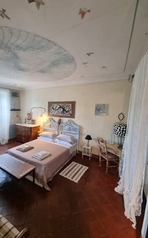 Affascinante camera da letto al B&B La Corte Ovada, Ovada, con letto bianco vintage, mobili antichi e soffitto decorato
