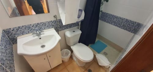 Shared bathroom at Casa do Sol Algarve Lagos with sink, toilet, shower and blue mat