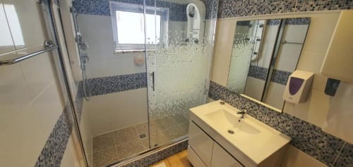 Modern bathroom with shower enclosure and sink in Casa do Sol Algarve hotel room, Lagos, Portugal