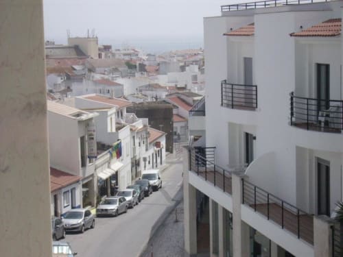 Vista da cidade desde a varanda da Casa do Sol Algarve em Lagos mostrando edifícios brancos e uma rua portuguesa estreita