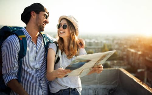 Pareja con mapa contemplando el paisaje de El Torno Cáceres desde la azotea de Casa Rural Villa del Jerte al atardecer