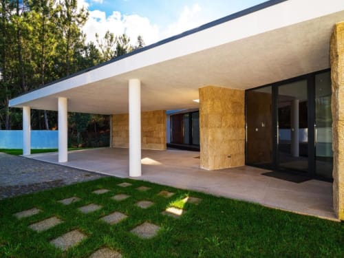 Vila moderna com terraço coberto, colunas brancas, detalhes em madeira e jardim verdejante na Casa da Luz Gerês, Vieira do Minho
