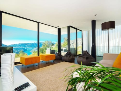 Sala de estar moderna com poltronas laranja, vista para montanha e rio em Casa da Luz Gerês, Vieira do Minho