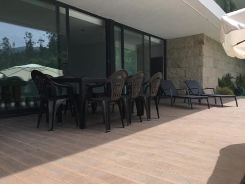 Terraço de moradia moderna na Casa da Luz Gerês com mobiliário de jantar preto, espreguiçadeiras e vistas de montanha em Vieira do Minho.