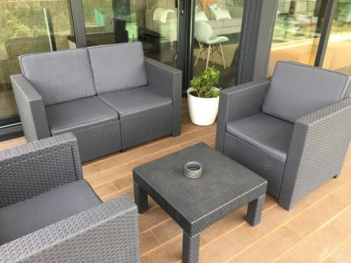 Conjunto de móveis de vime moderno no terraço da villa Casa da Luz Gerês com almofadas cinzentas e planta em vaso