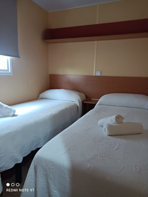 Twin beds with white linens in Bungalow G at Buda Beach hotel, Chipiona, Spain