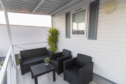 Muebles de ratán negro en la terraza cubierta del Bungalow H del hotel Buda Beach, Chipiona