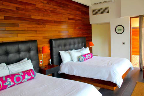Modernes Hotelzimmer im Isla Tajín Beach & River Resort in Tuxpan mit zwei Betten, schwarzen Lederkopfteilen und bunten Kissen