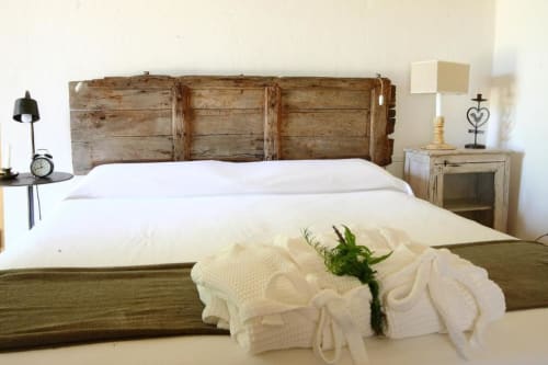 Camera da letto rustica in Masseria Picca Picca, Morciano di Leuca, con testata in legno invecchiato, biancheria bianca e stile vintage