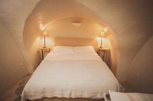 Chambre douillette au Gîte Lourmarin : lits aux draps blancs, plafond voûté, ambiance chaleureuse et lampes de chevet