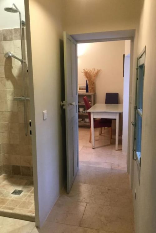Hallway view of Courtyard Apartment in Lourmarin with shower, desk area, and terrace access at Ancienne Maison des Gardes