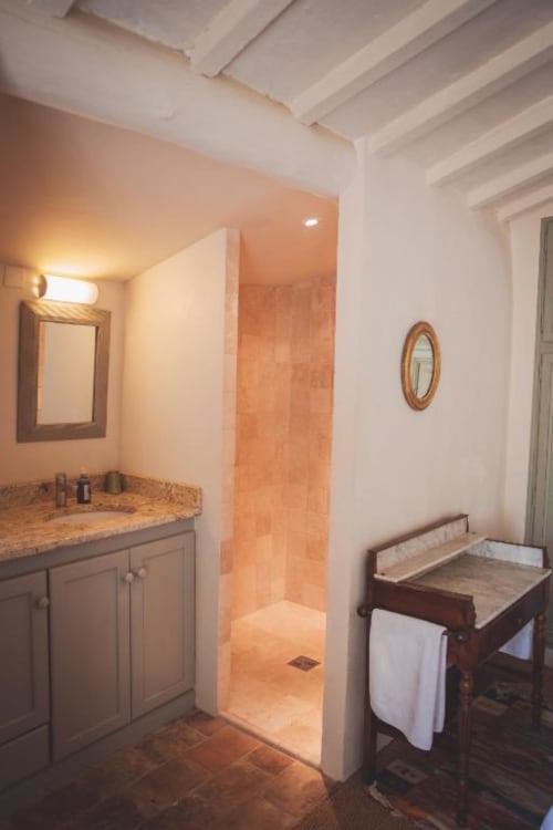 Elegant bathroom in Ancienne Maison des Gardes, Lourmarin with granite vanity, walk-in shower, and terracotta tile floors