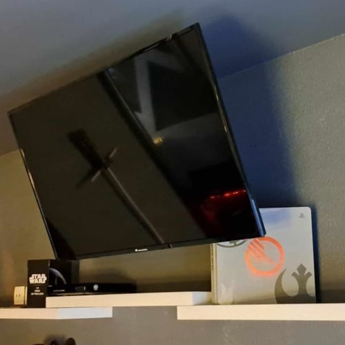 Espace de divertissement dans la chambre de l'hôtel Les Deux Porches avec télévision écran plat, console de jeux et figurines Star Wars exposées