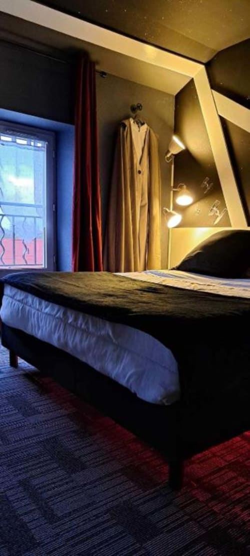 Chambre moderne aux Deux Porches à Verrières : lit confortable, miroir illuminé, fenêtre avec rideaux et décoration contemporaine