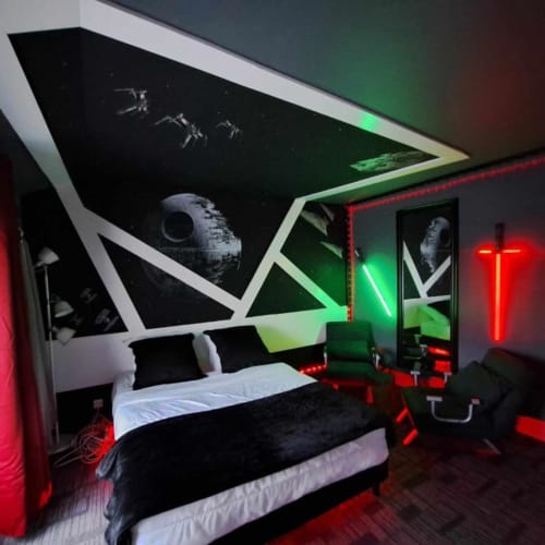 Chambre thématique Star Wars à l'hôtel Les Deux Porches à Verrières avec éclairage néon et décoration murale Étoile de la Mort
