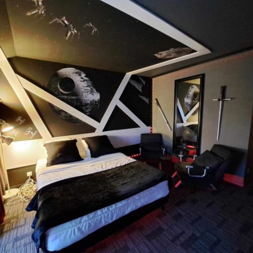 Chambre thématique Star Wars à l'hôtel Les Deux Porches avec fresque murale Étoile de la Mort, décoration de vaisseau spatial au plafond et ambiance sombre