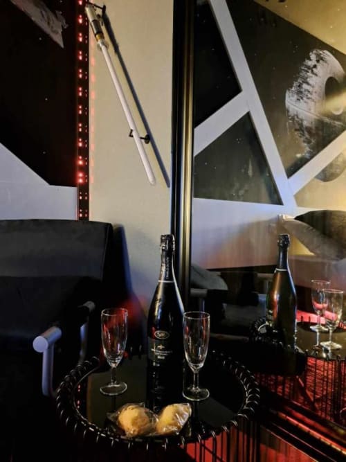 Mise en place champagne élégante à l'hôtel Les Deux Porches à Verrières avec verres, bouteilles et mobilier raffiné