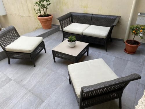 Zona salotto esterna con arredamento in vimini nero e cuscini bianchi presso My Florentine Apartment, Firenze