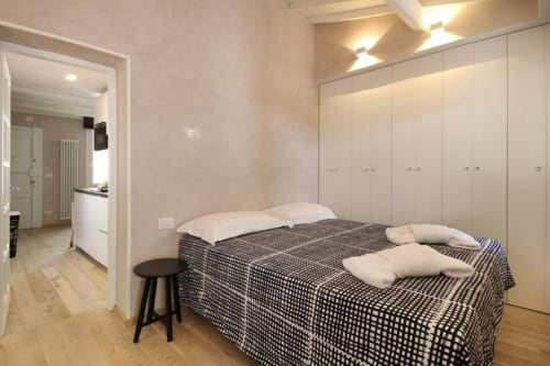 Camera da letto moderna nel Mio Appartamento Fiorentino con letto matrimoniale, armadi bianchi e bagno ensuite