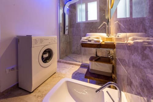 Bagno moderno nell'appartamento di Firenze con lavatrice, lavabo, doccia e illuminazione ambient