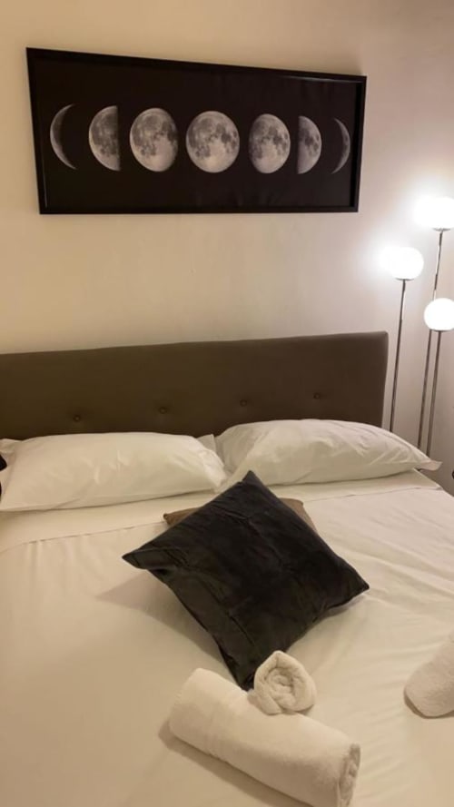 Camera da letto moderna in My Florentine Apartment a Firenze con arte murale delle fasi lunari sopra il letto