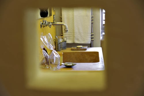 Bagno della camera Pesce presso Masseria Picca Picca B&B con pareti gialle, lavabo, rubinetteria e asciugamani bianchi