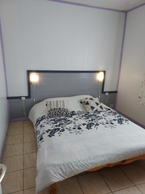 Chambre moderne à la villa Au pied des Sources, Cilaos, avec tête de lit illuminée et linge de lit à motifs