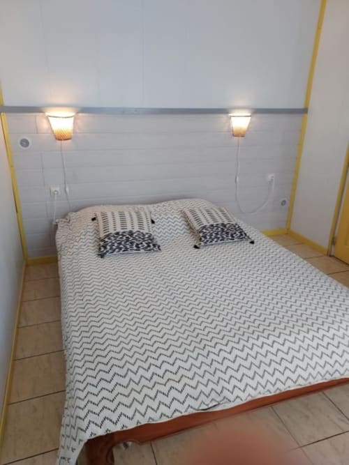 Chambre douillette de la villa Au pied des Sources à Cilaos avec lit double, linge de lit à motifs et éclairage ambiant