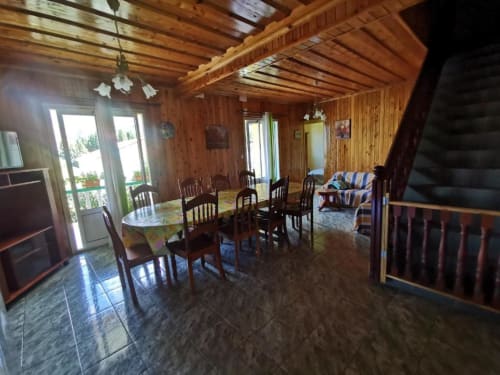 Intérieur de villa en bois à Au pied des Sources à Cilaos avec salle à manger, portes donnant sur le jardin et espace de vie