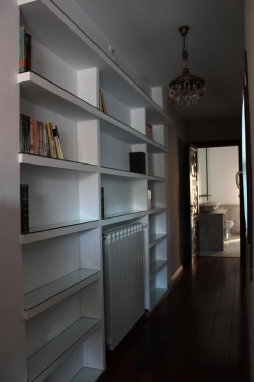 Estantería empotrada moderna con libros y decoración en la habitación del hotel Suite Comares Granada