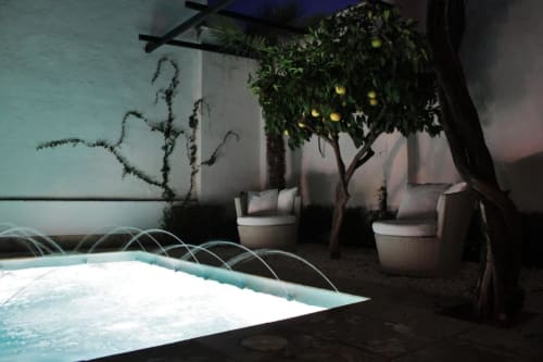 Terraza Suite Comares Granada con piscina iluminada, limonero y zona de descanso al atardecer