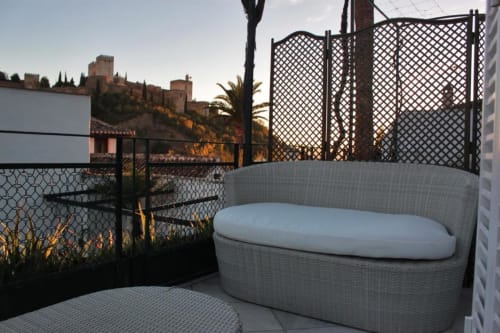 Zona de descanso en la azotea de Suite Comares Granada con vistas a la fortaleza de la Alhambra al atardecer