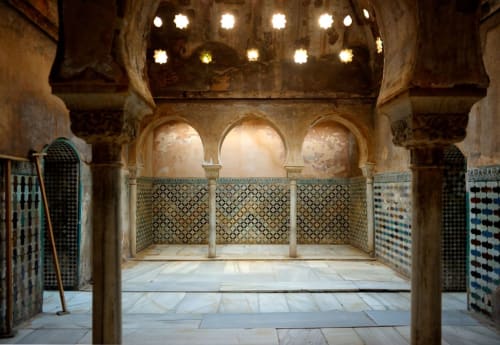 Baño morisco ornamentado en Suite Comares Granada con arcos decorativos, azulejos artesanales e iluminación ambiental