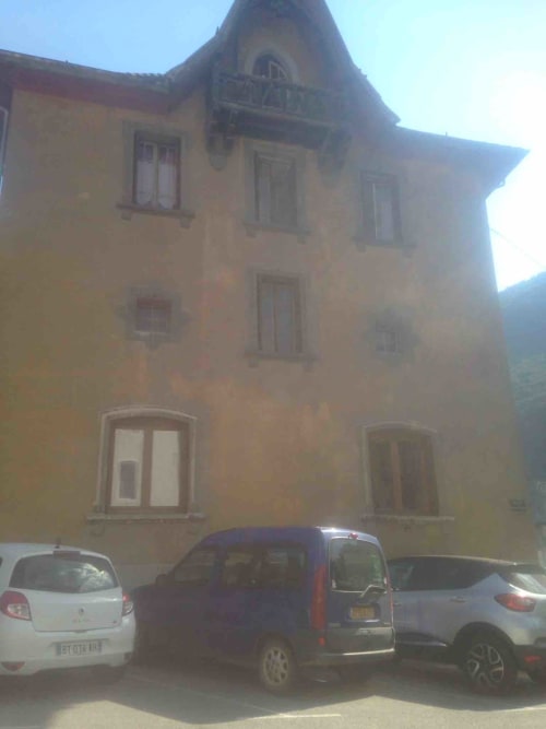 La Montagnette B&B à Moutiers, France - façade historique en pierre jaune avec voitures garées