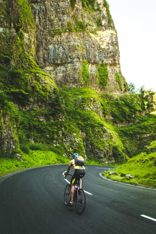 Cyclist riding through lush green valley near Haydon Bridge, Hexham