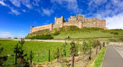Bamburgh Castle on hilltop overlooking green fields near Haydon Bridge, Hexham