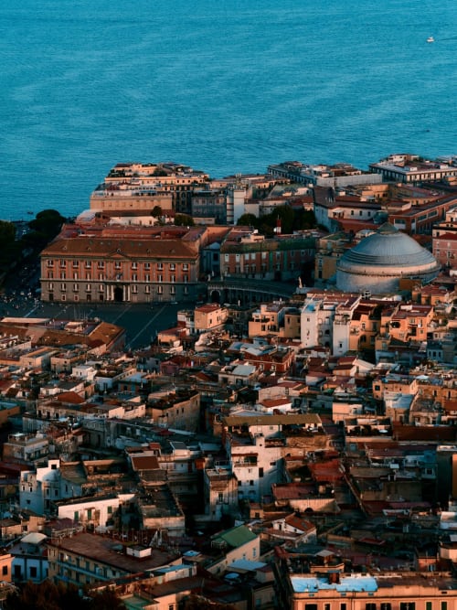 Vista aerea della costiera napoletana con edifici colorati e mare turchese, mostra la posizione dell'hotel Encanto