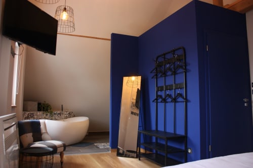 Suite chambre moderne chez Théière & Couverts avec mur d'accent bleu audacieux, baignoire, décor contemporain à Cernay