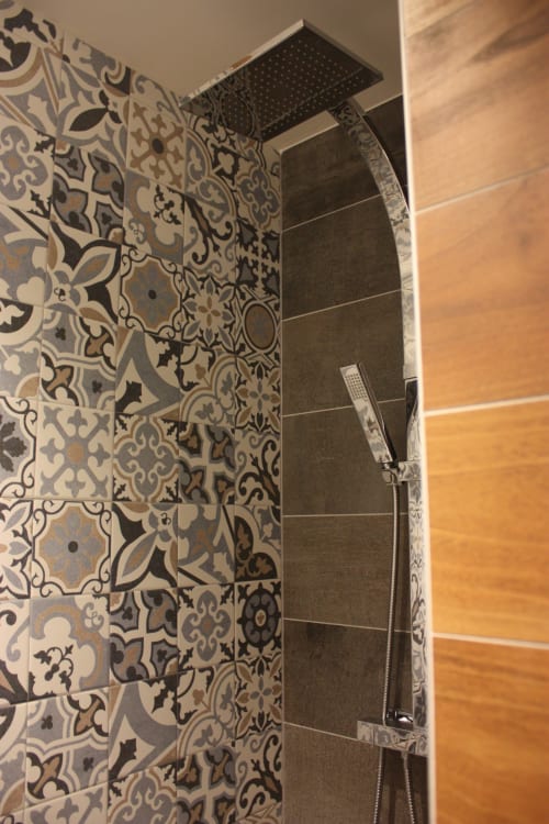 Paroi de douche aux motifs ornementaux chez Théière & Couverts à Cernay avec pomme de douche pluie moderne