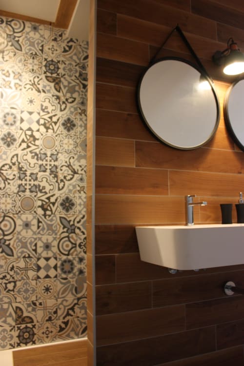 Salle de bain moderne à Théière & Couverts avec carrelage motifs, accents bois, miroir rond et lavabo blanc
