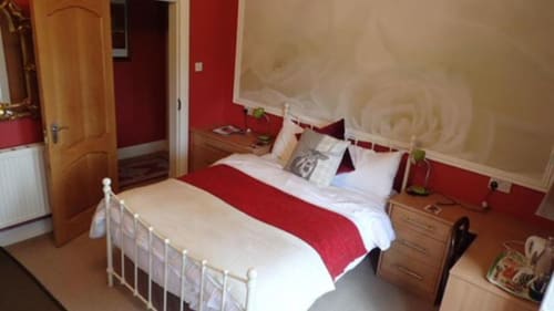 Double room at Arrochoile B&B Glasgow with red and white bedding, wooden doors, and lake view wallpaper