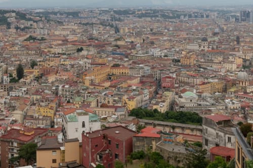 Vista aerea del paesaggio urbano di Napoli con edifici storici colorati e tetti rossi caratteristici