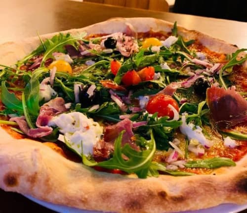 Pizza gourmande à la roquette, jambon de Parme et légumes frais à La Montagnette, Moutiers