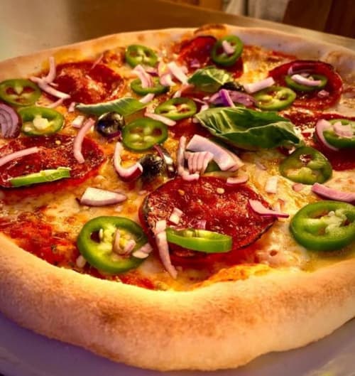 Pizza épicée aux pepperonis, jalapeños, oignons rouges et olives noires à La Montagnette à Moutiers
