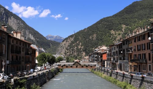 Vallée alpine à Moutiers avec bâtiments en terre cuite et montagnes enneigées, localisation du gîte La Montagnette