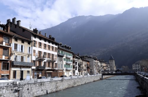 La Montagnette BnB à Moutiers, France : bâtiments historiques au bord de la rivière avec les Alpes en arrière-plan