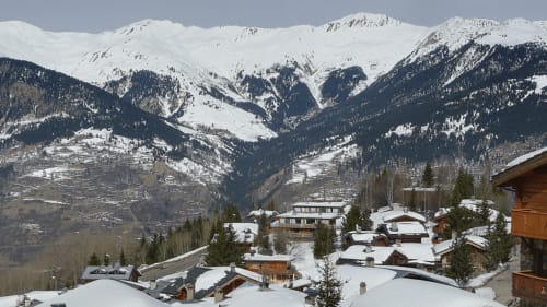Chalets enneigés de La Montagnette B&B avec pics alpins et montagnes boisées à Moutiers, France